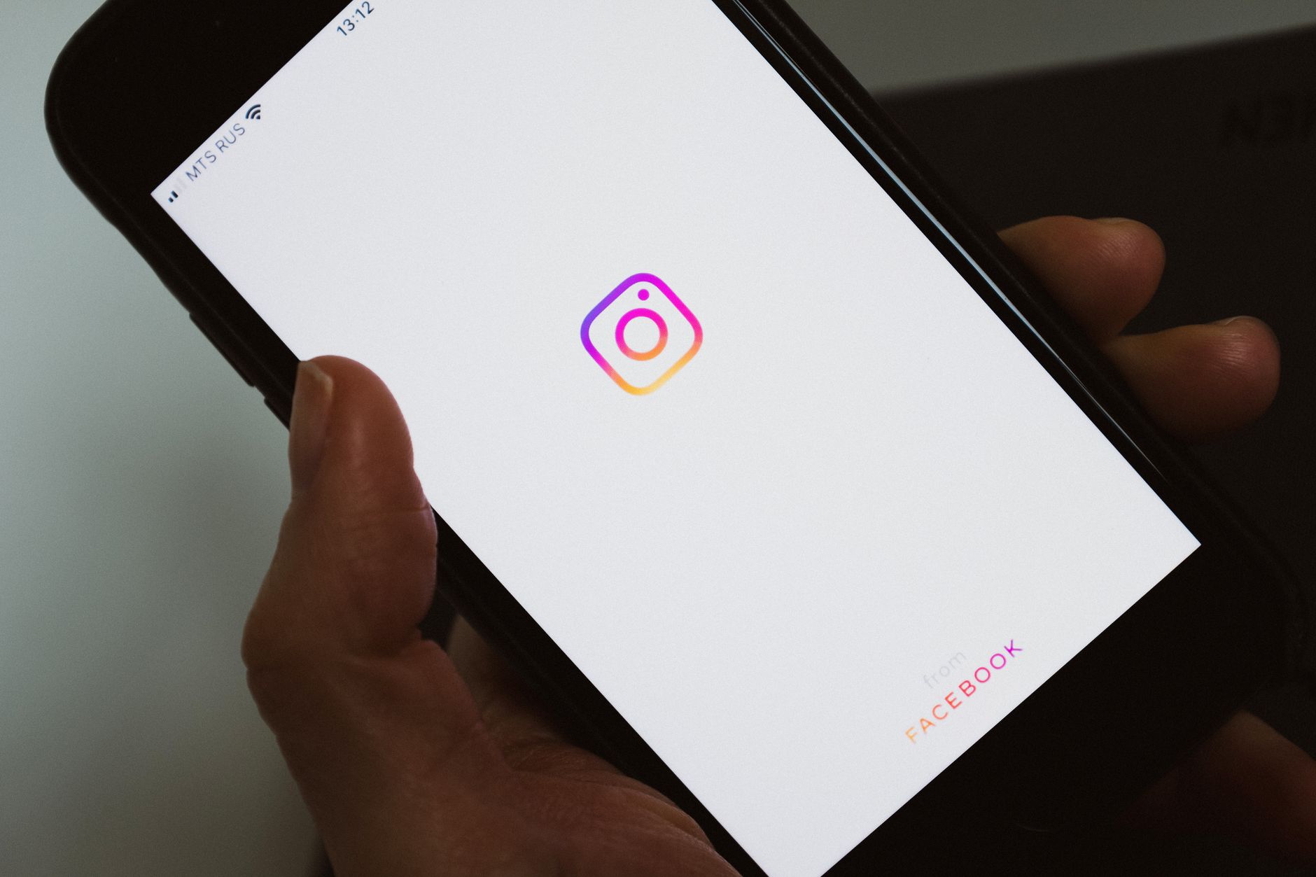 Personne sans visage prenant un téléphone portable et montrant un écran vierge avec le logo d'une application de médias sociaux tout en faisant une pause et en naviguant sur Internet
