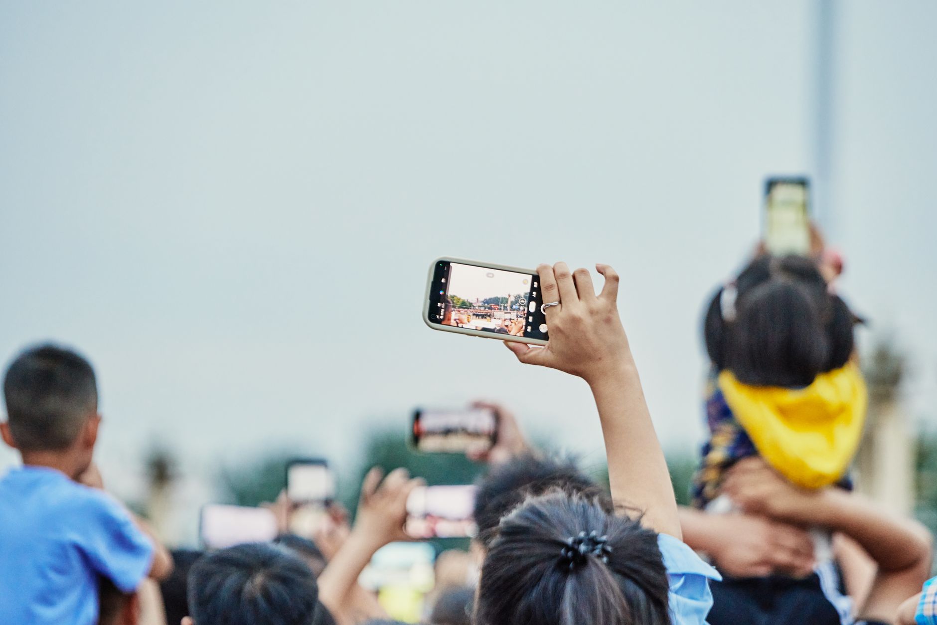 Une foule animée capturant un événement sur smartphone, montrant l'engagement numérique moderne.